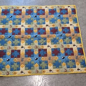 Handmade baby or lap quilt featuring a combination of patchwork